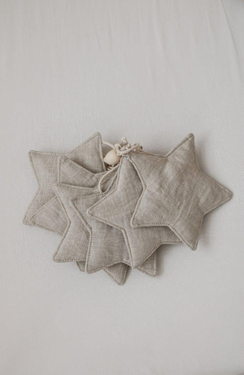 4. Flat lay of linen star garland with wooden beads on light fabric background