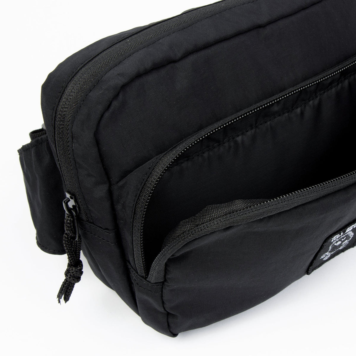 7. Open view of black Stinky Retro Waist Bag by Moomin showing main compartment