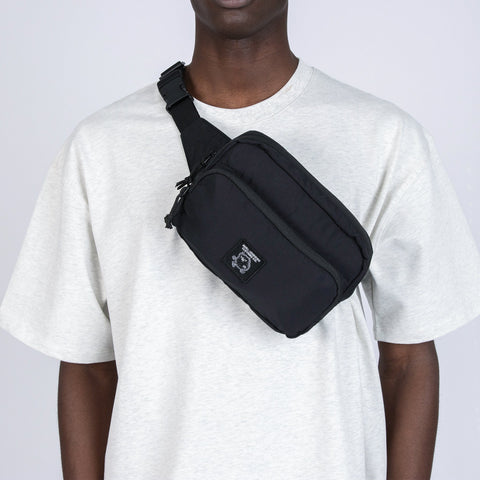 1. Unisex black Stinky Retro Waist Bag by Moomin worn crossbody by male model in studio