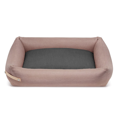 2. Pink and grey Stokke dog bed by Labbvenn with removable cover and leather belt, shown in studio setting highlighting spacious design and hypoallergenic materials.