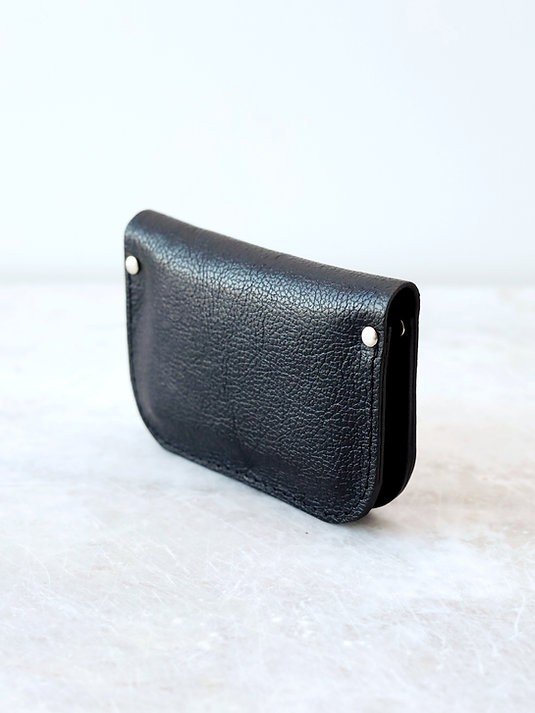 4. Side view of black textured leather wallet by TOKS VISOKS on marble surface
