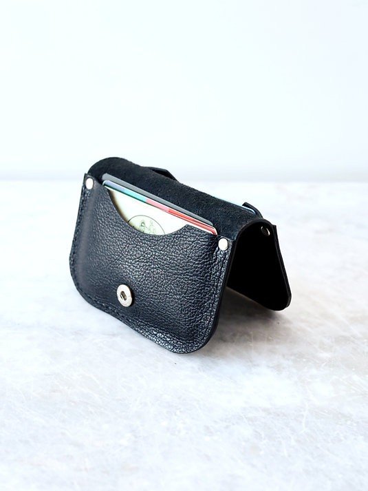 5. Black textured leather wallet by TOKS VISOKS partially open with cards visible