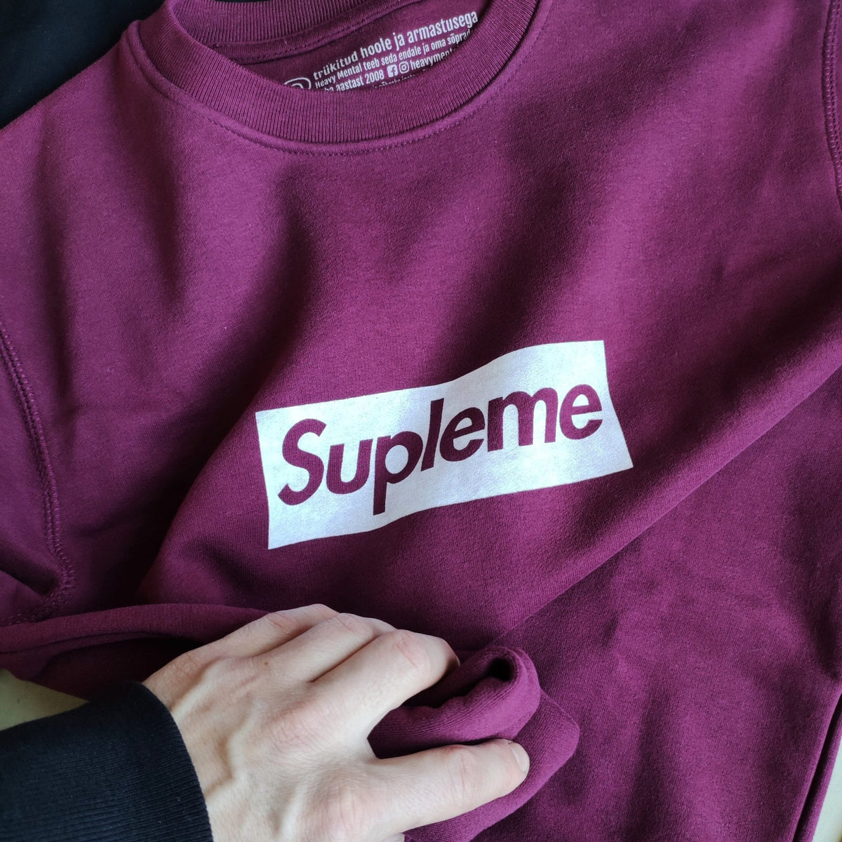 2. Close-up of Supleme logo on Heavy Mental bordeaux sweatshirt, highlighting soft cotton-polyester blend
