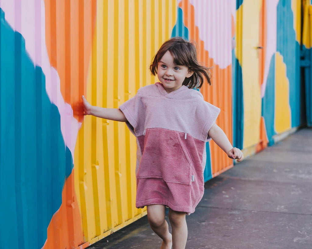 1. Child in pink Surfbunny bath poncho with bunny ears running by colorful wall