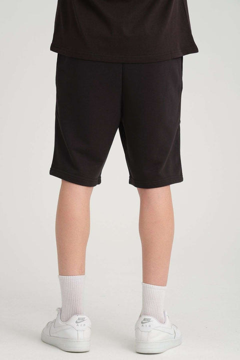 4. Back view of black sweat shorts worn by a man, showing fit and length
