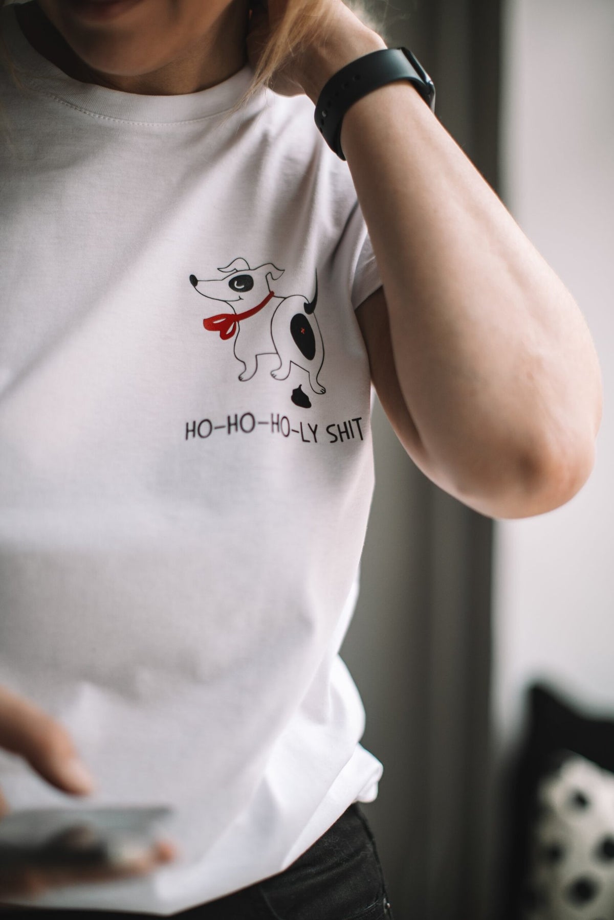 2. Close-up of person wearing white T-shirt with dog graphic and 'Ho-ho-ho-ly sh*t' text, indoors