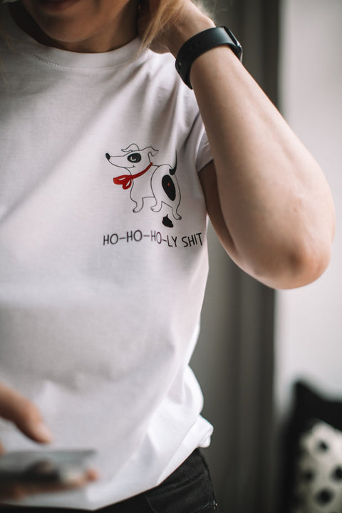 2. Close-up of person wearing white T-shirt with dog graphic and 'Ho-ho-ho-ly sh*t' text, indoors