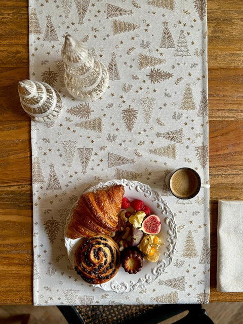 1. Golden Forest table runner with festive motif on wooden table, featuring pastries and coffee, creating a cozy dining setting