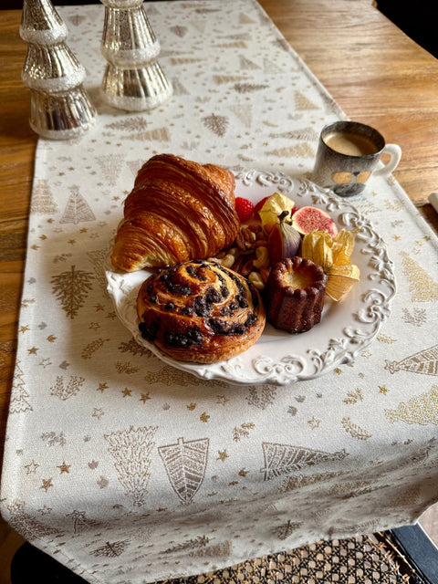 5. Golden Forest table runner with pastries and coffee, silver tree decorations, creating a festive dining atmosphere