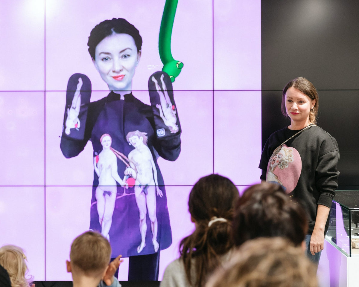 1. Presentation with woman in front of screen displaying Katrin Valgemäe apron and oven gloves with Adam and Eve prints