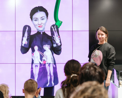 1. Presentation with woman in front of screen displaying Katrin Valgemäe apron and oven gloves with Adam and Eve prints