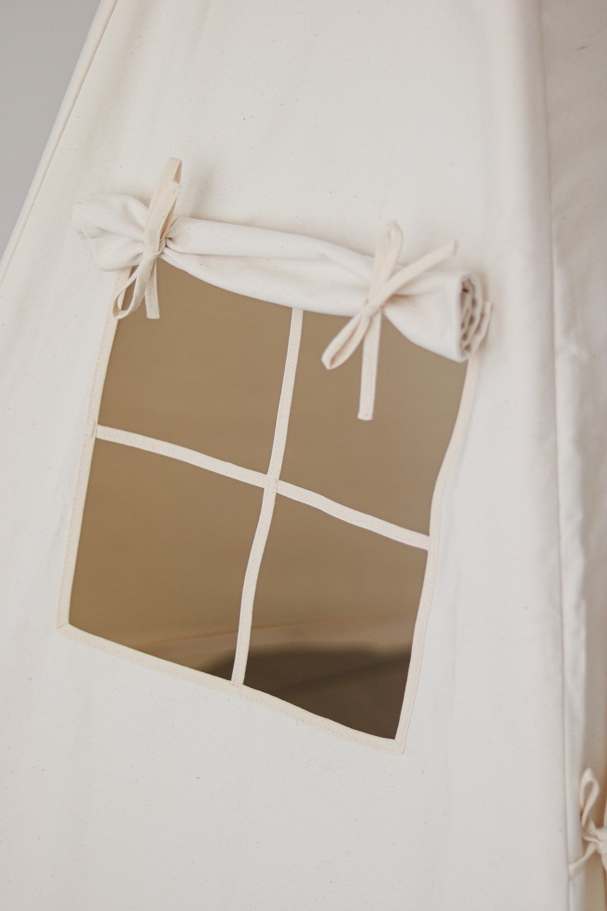 3. Close-up of beige teepee tent window with tied curtain detail