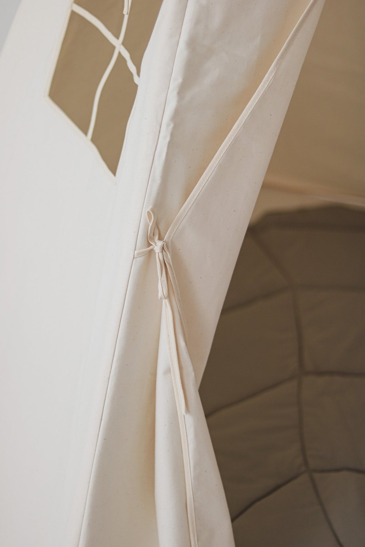 3. Close-up of beige teepee tent entrance with tied curtain detail