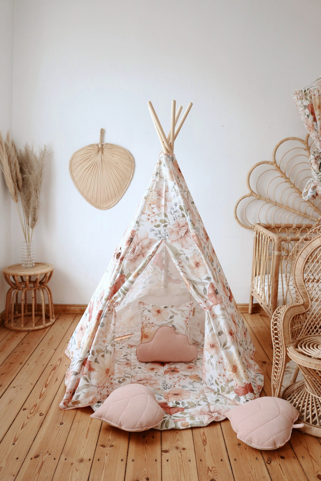 3. Floral teepee tent with pink heart-shaped cushions in a wooden-floored room