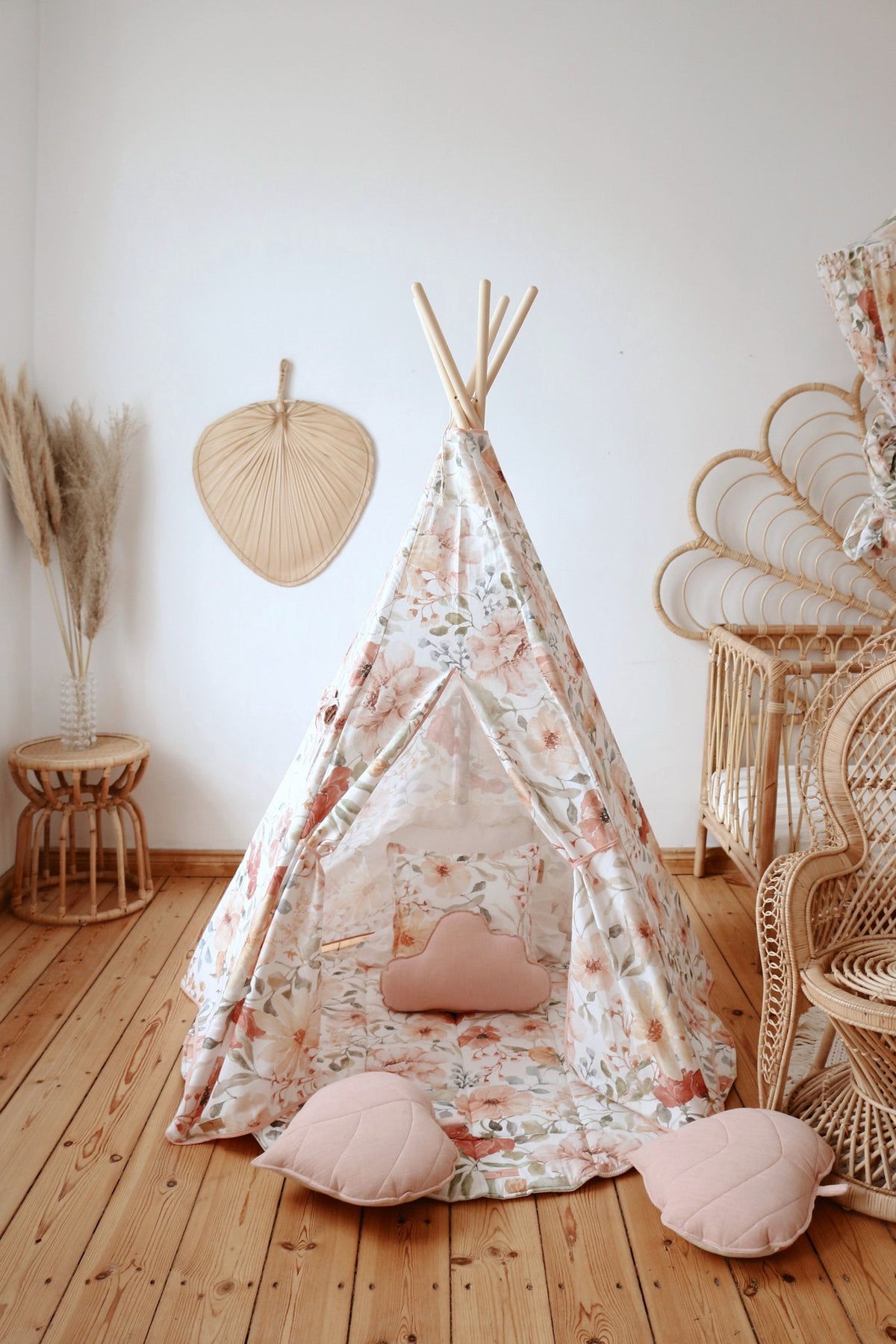 3. Floral teepee tent with pink heart-shaped cushions in a wooden-floored room
