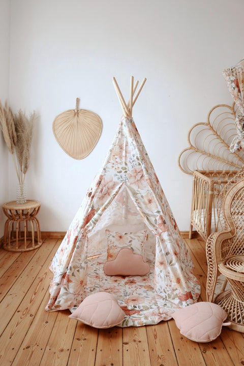 3. Floral teepee tent with pink heart-shaped cushions in a wooden-floored room