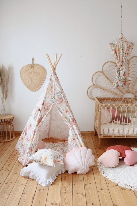 4. Floral teepee tent in a nursery with wicker furniture and pink cushions