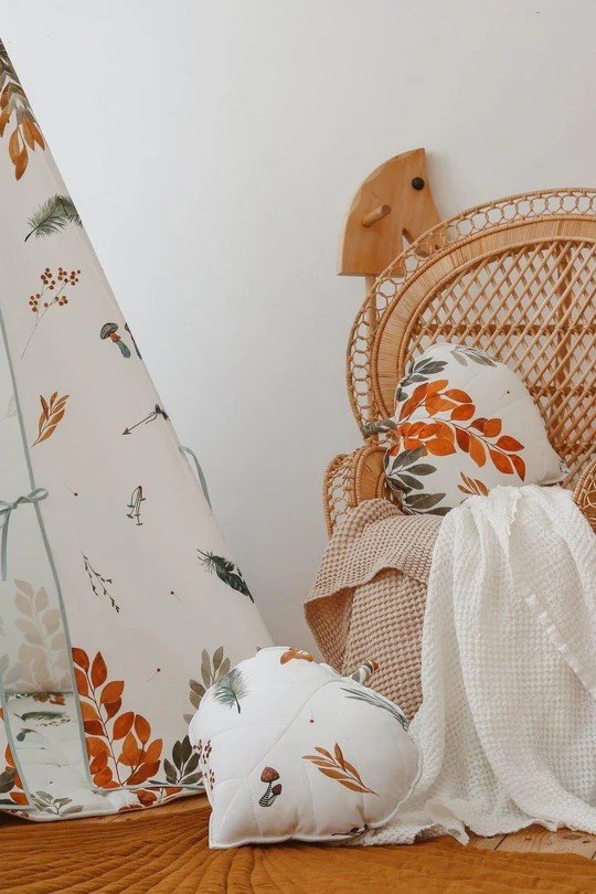 5. Detail of teepee tent with forest pattern next to wicker chair and cushions