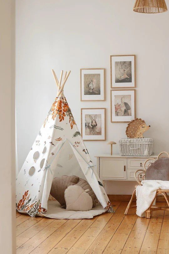 2. Cozy children's room with teepee tent featuring forest friends pattern, surrounded by framed art and wicker furniture