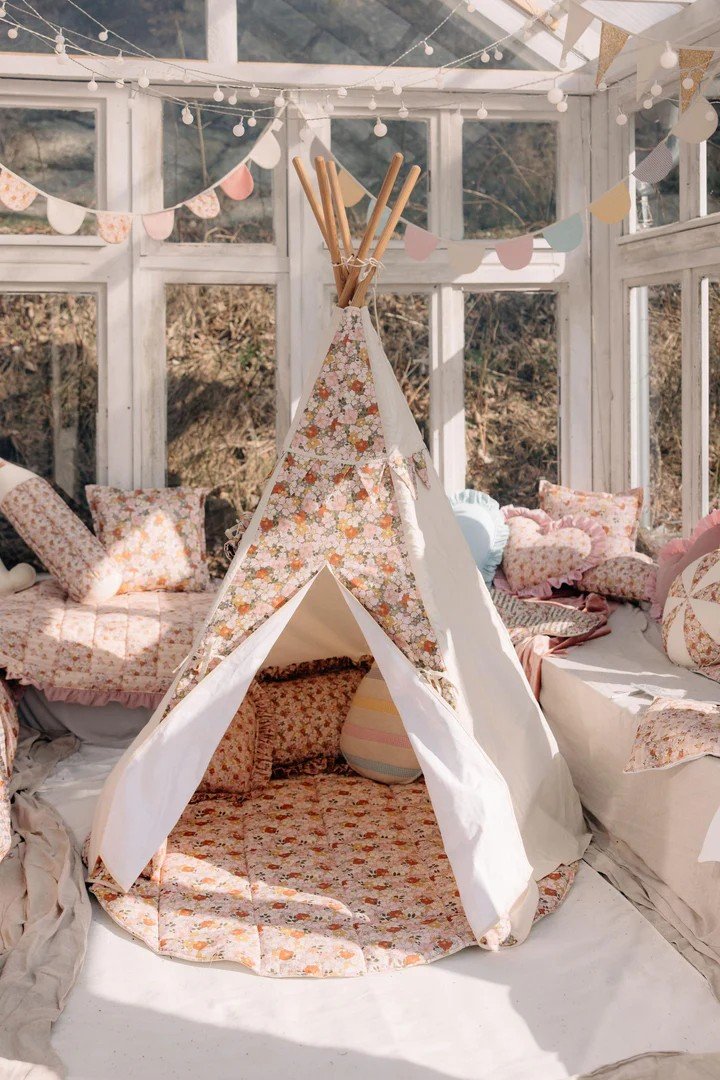1. Moi Mili Green Garden teepee tent with floral print in a bright room with cushions and decorative bunting