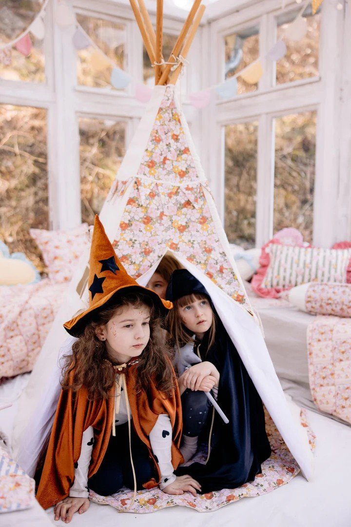 1. Three children in costumes playing inside Moi Mili Green Garden teepee tent with floral print in a sunlit room