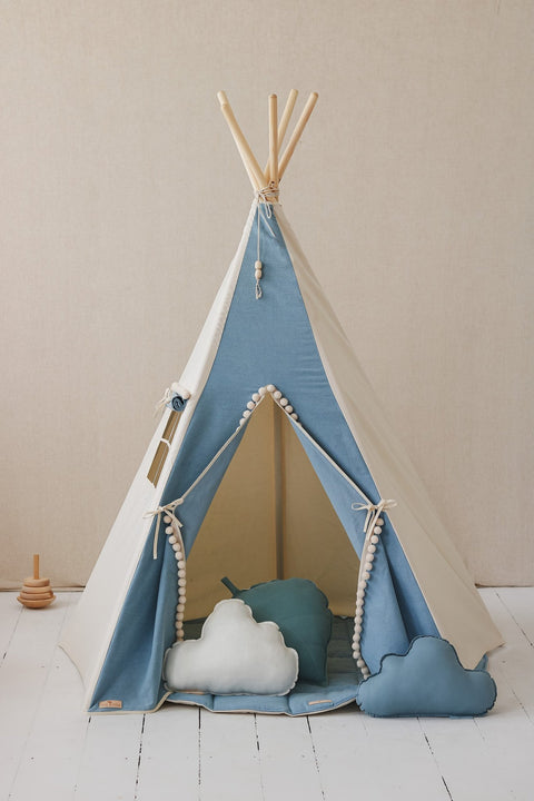 4. Blue and white children's teepee tent with pompoms, featuring cloud pillows inside, on white floor with beige background.
