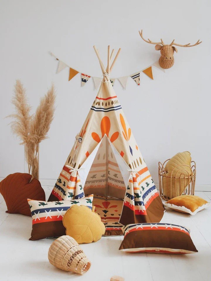 1. Children's playroom with Moi Mili teepee tent featuring geometric prints, surrounded by decorative pillows and a faux deer head on the wall
