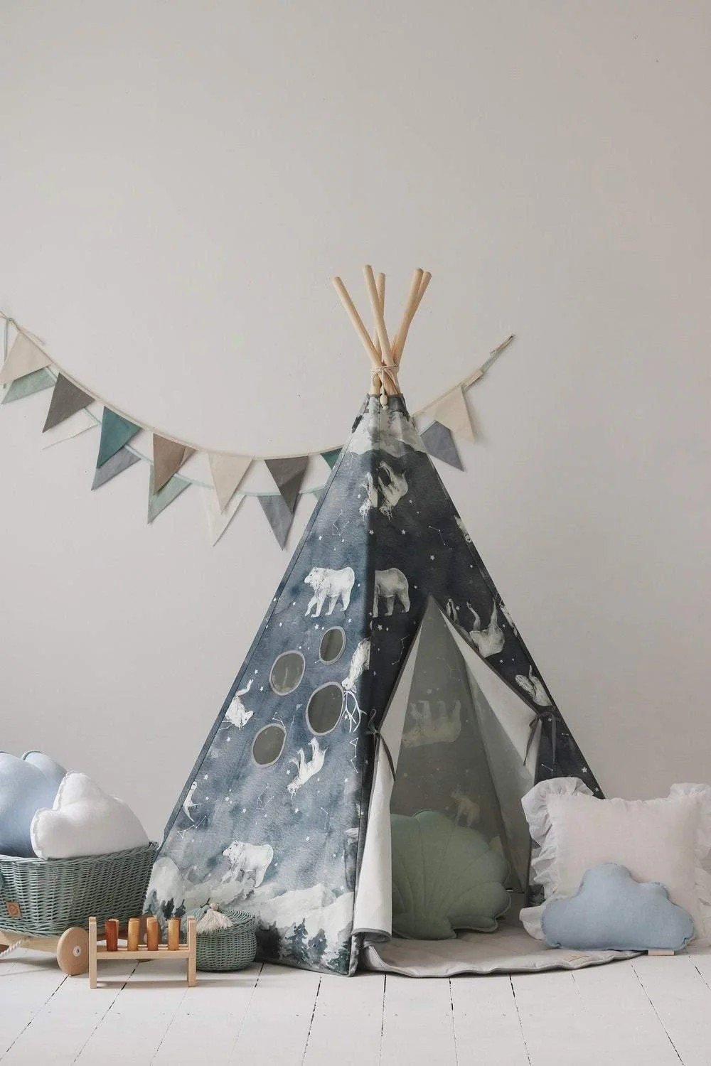 1. Children's teepee tent with starry animal pattern in a cozy room setting, featuring decorative pillows and toys, against a white wall with bunting