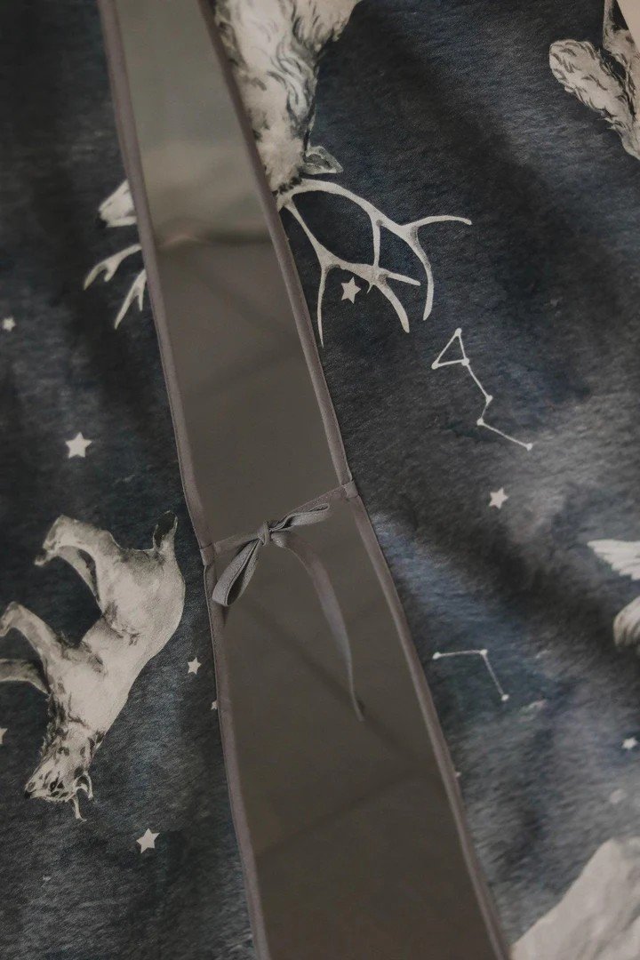 3. Detail of tie closure on dark blue teepee tent fabric with starry animal pattern and constellations