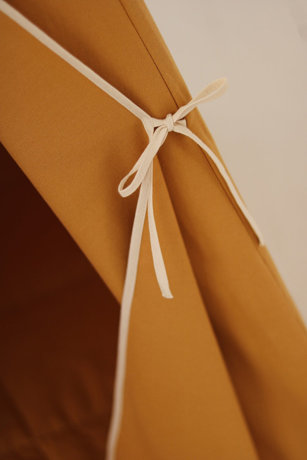 3. Close-up of tie detail on orange teepee tent, highlighting craftsmanship