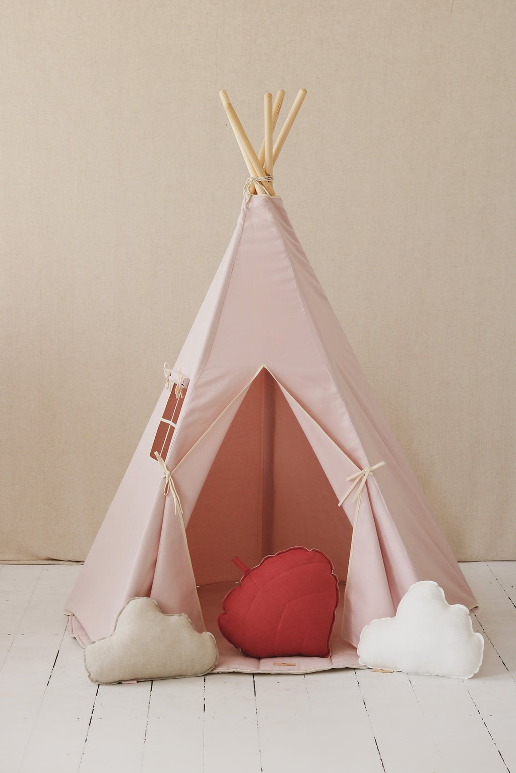 2. Pink teepee tent with open entrance, red and white cloud cushions inside, on light wooden floor