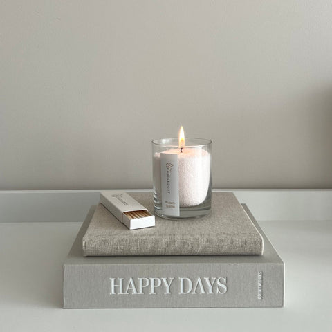 2. Candledust Nordic Lights powdered candle lit on a book stack, showcasing elegant design and relaxing atmosphere
