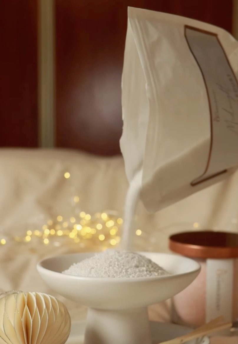 4. Pouring Candledust powder into a bowl with festive lights in background