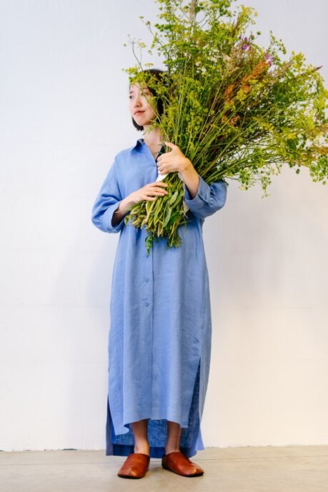 1. Woman wearing Kyoto brown slippers by Omaking, holding a bouquet, showcasing minimalist design