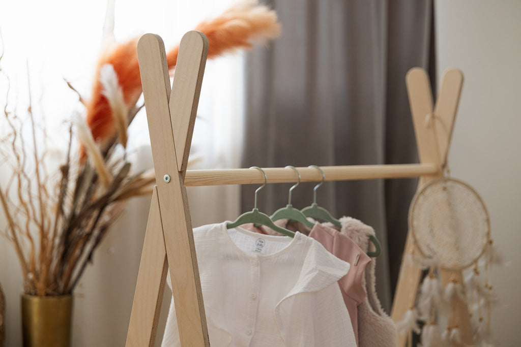 3. Close-up of MeowBaby Tipi clothing rack with children's clothes on hangers and decorative dreamcatcher