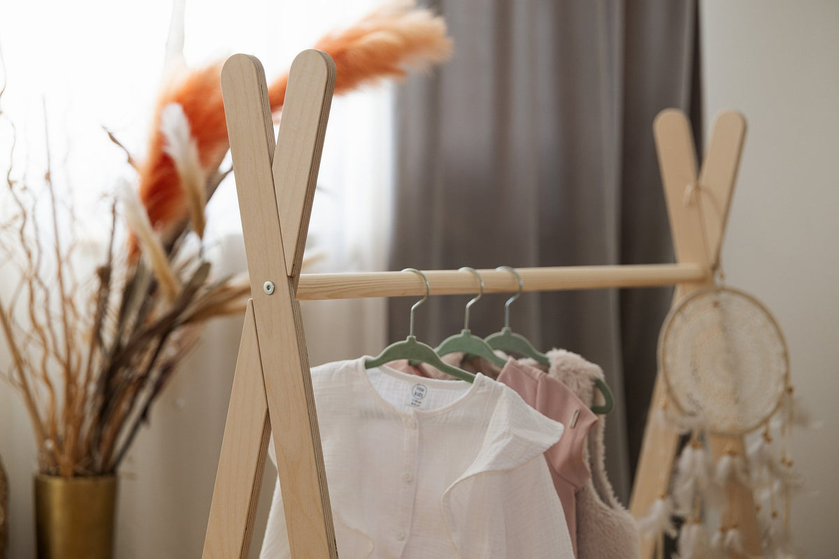 3. Close-up of MeowBaby Tipi clothing rack with children's clothes on hangers and decorative dreamcatcher