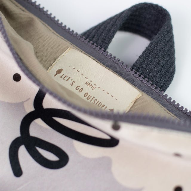 8. Close-up of Muni sheep backpack interior, showing name tag and zipper detail