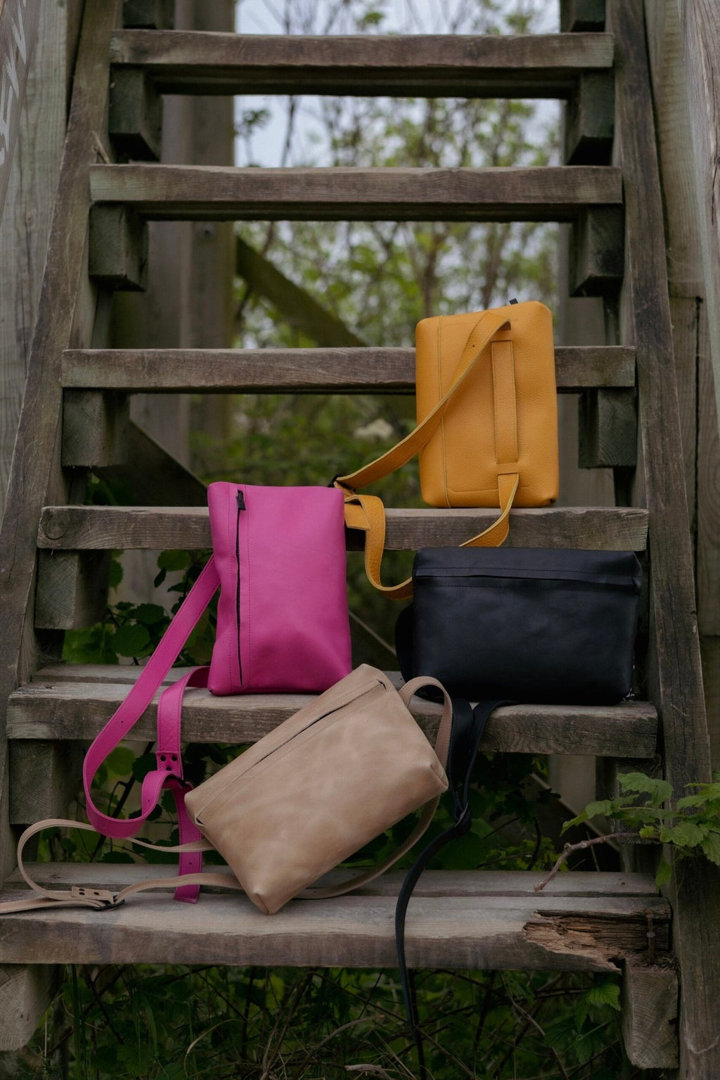 3. Collection of Omaking bags including pink TOKU Lisbon bag on wooden stairs
