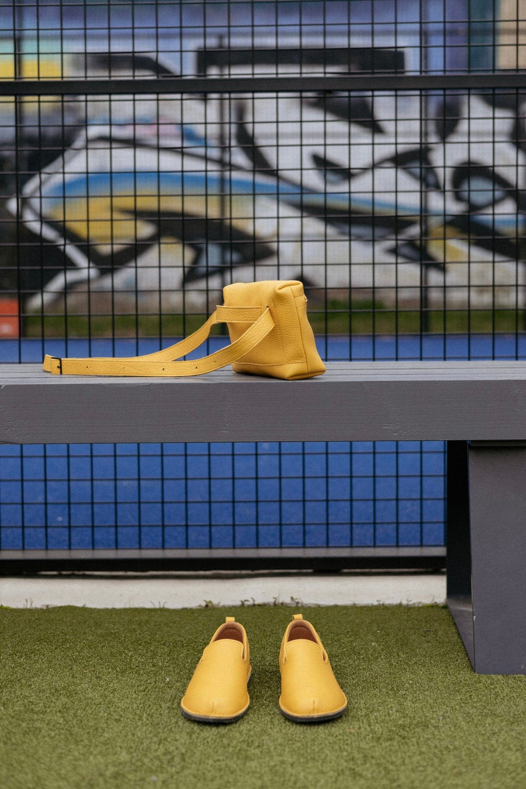 3. Yellow TOKU Lisbon bag by Omaking on a bench with matching shoes, highlighting vibrant color and style