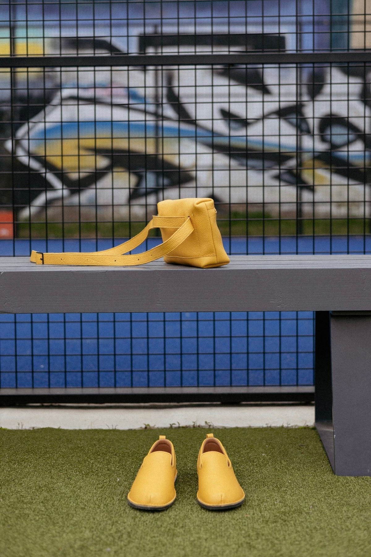 3. Yellow TOKU Lisbon bag by Omaking on a bench with matching shoes, highlighting vibrant color and style