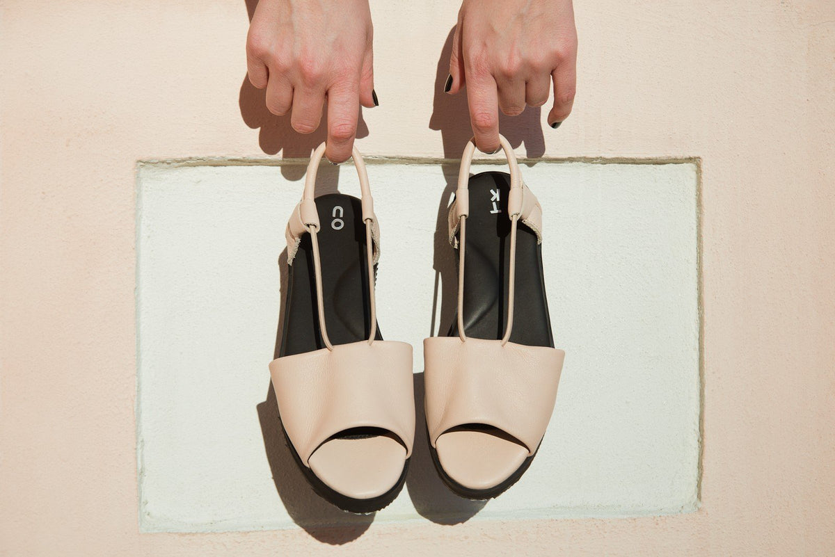 1. Women's nude TOKU Berlin sandals by Omaking, held by hands, showcasing leather upper and ergonomic design