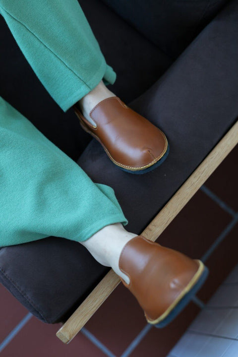 1. Lifestyle image of TOKU London Classic Shoes in Ocre worn by a person in green pants, showcasing the shoe's fit and style