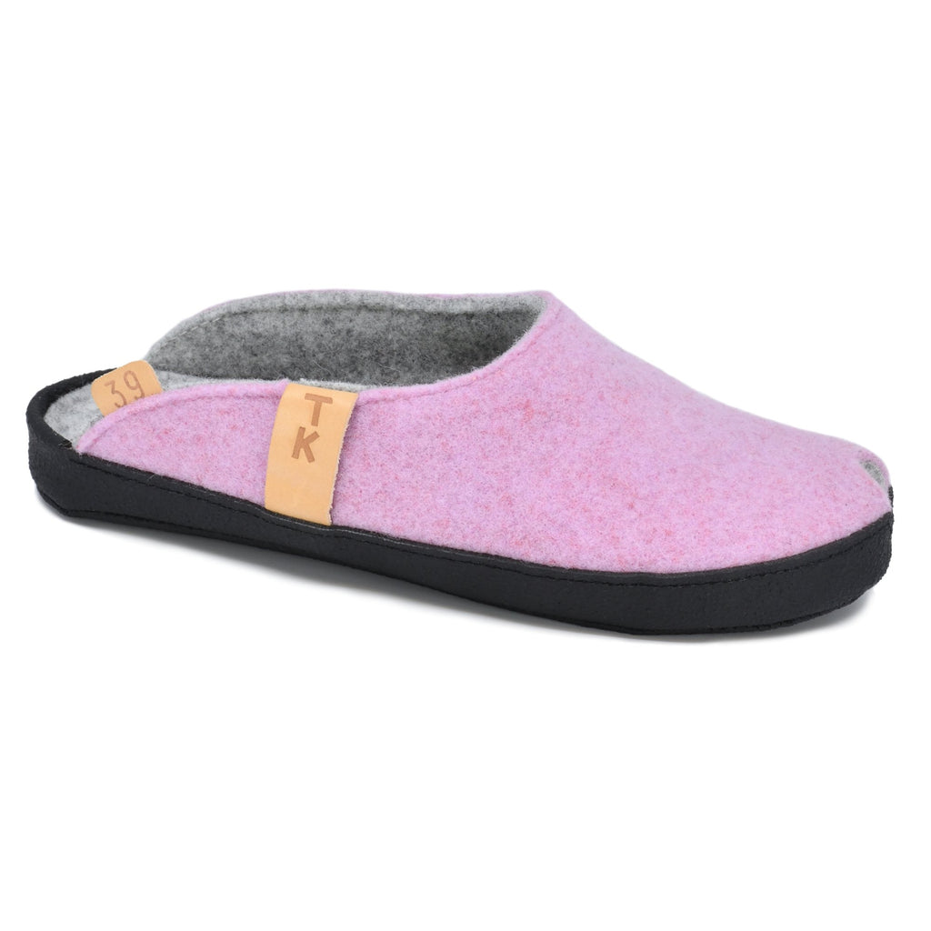 2. Side view of TOKU Brussels light pink slippers with black sole and TK branding, studio setting