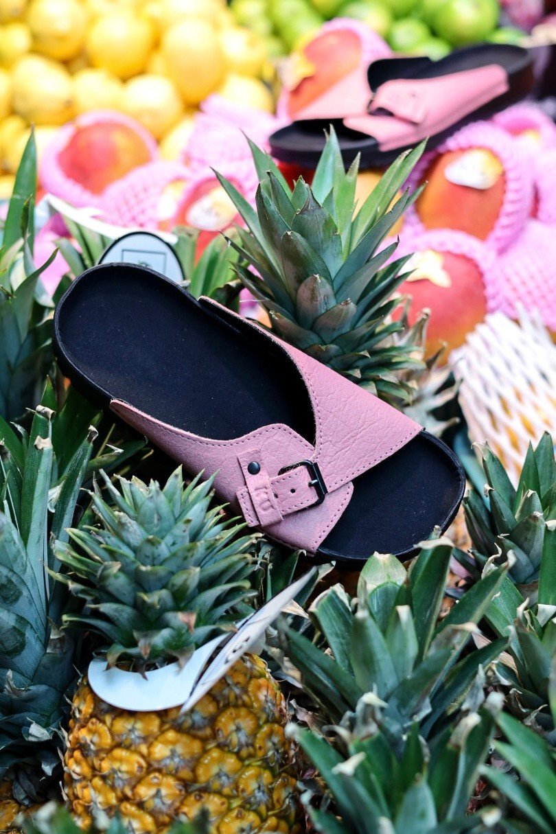 1. TOKU Rome Vegan Sandals in pink displayed among pineapples, highlighting sustainable Piñatex material