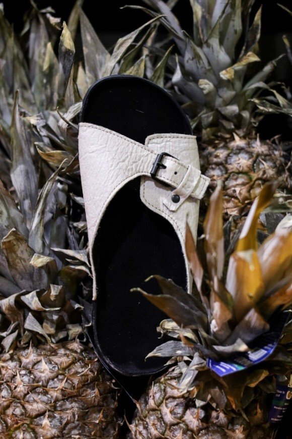 1. TOKU Rome Vegan Sandal in white displayed on pineapples, highlighting sustainable Piñatex material
