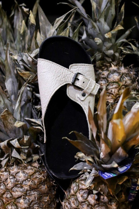1. TOKU Rome Vegan Sandal in white displayed on pineapples, highlighting sustainable Piñatex material