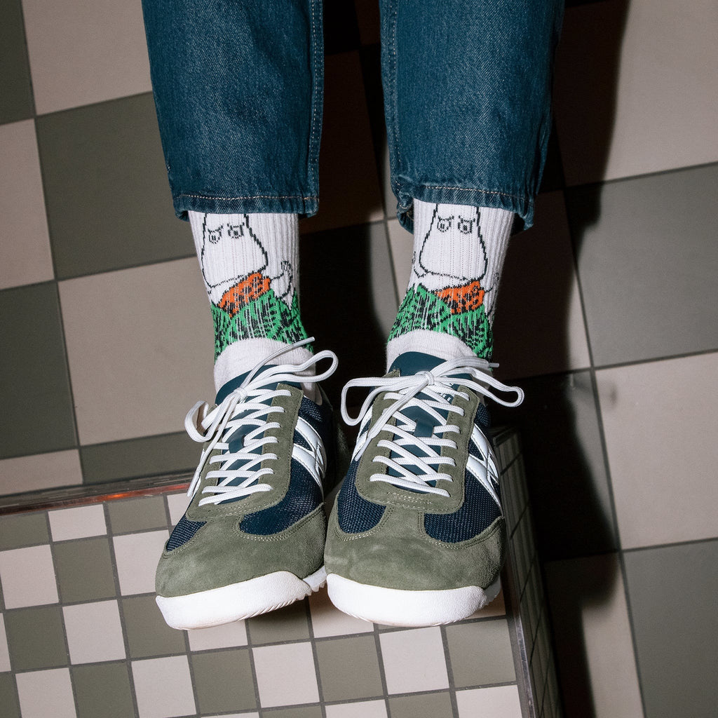 1. Men's Moomin Jungle retro socks in white with jungle design, worn with sneakers in lifestyle setting