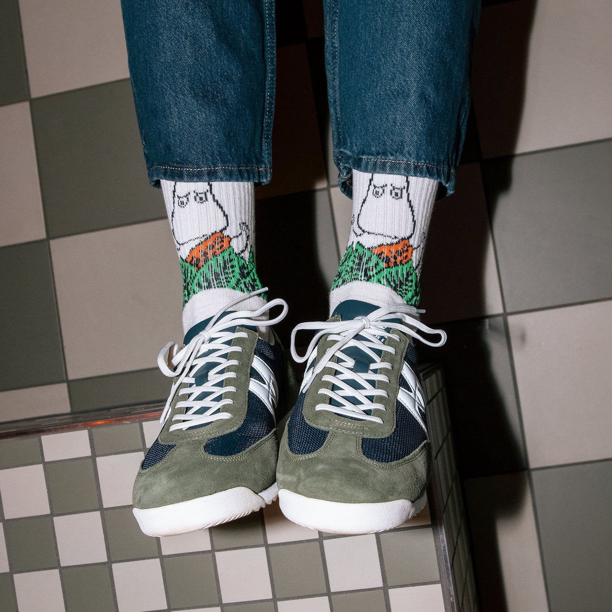 1. Men's Moomin Jungle retro socks in white with jungle design, worn with sneakers in lifestyle setting