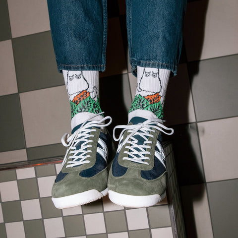 1. Men's Moomin Jungle retro socks in white with jungle design, worn with sneakers in lifestyle setting