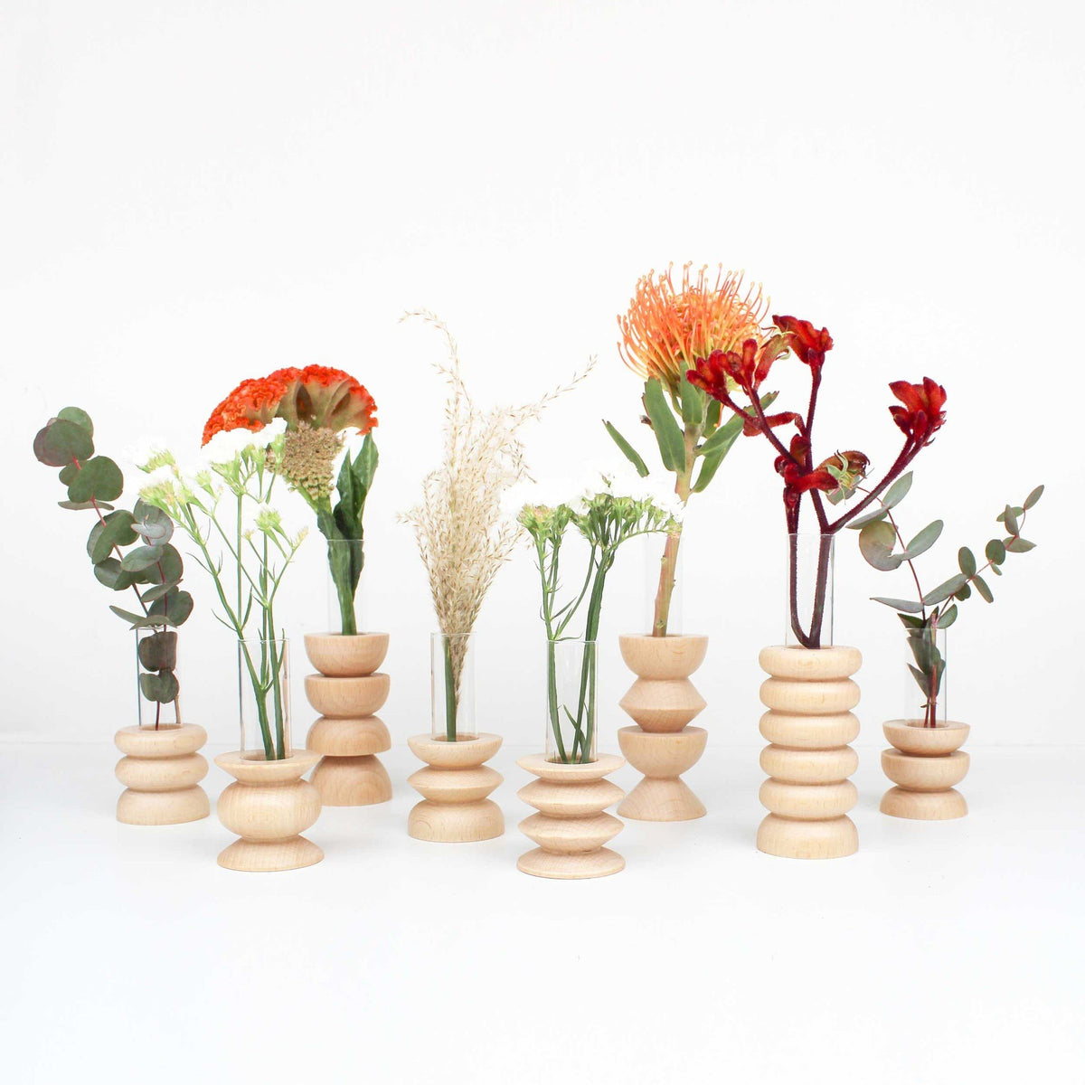 5. Collection of Totem Wooden Vases by 5mm Paper on a shelf, featuring minimalist decor with beech wood and glass tube